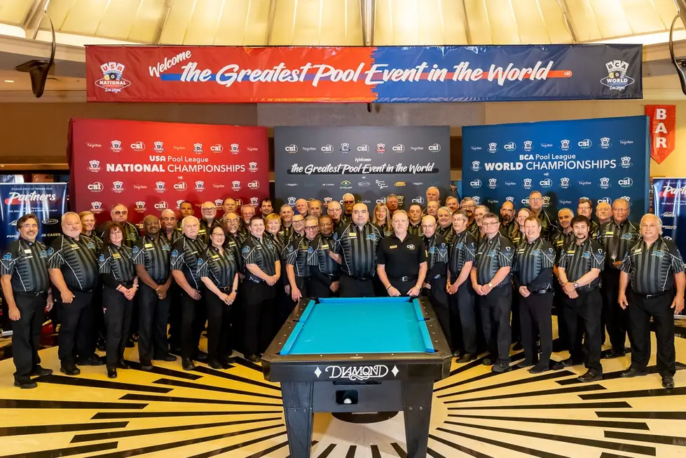 Tournament officials gathered around a table under the National Championships banner